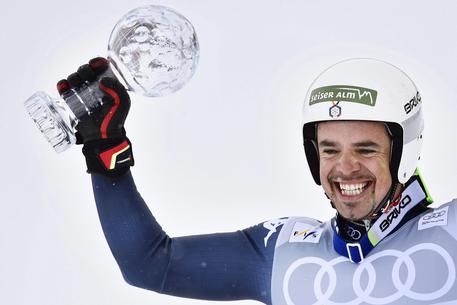 epa05214018 Peter Fill of Italy celebrates with the crystal globe after taking the overall Downhill World Cup title following the men's Downhill race at the FIS Alpine Skiiing World Cup Finals in St. Moritz, Switzerland, 16 March 2016.  EPA/GIAN EHRENZELLER